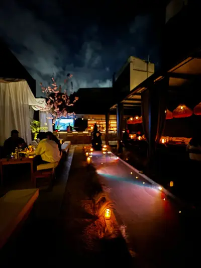 Salón de PAUKA con iluminación tenue, mesas, sillones y una gran escultura de Buda al fondo.